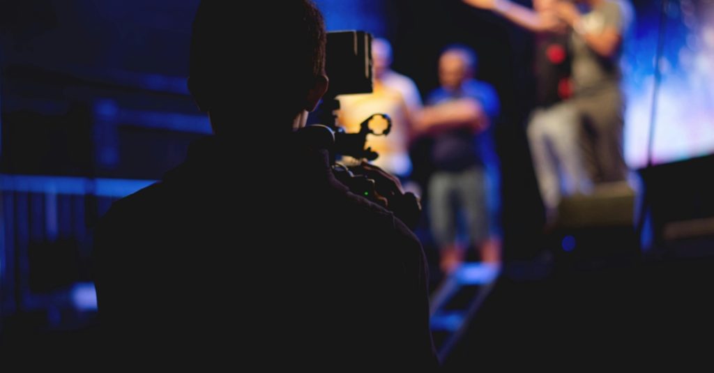 A person using a camera to film video content